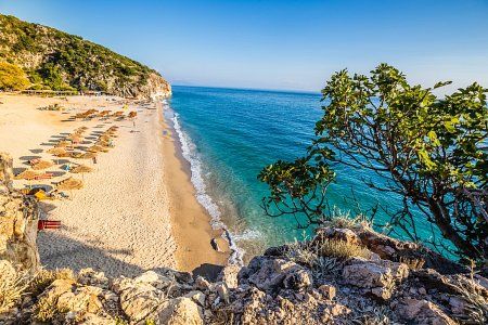 Słoneczna plaża w Albanii z parasolami