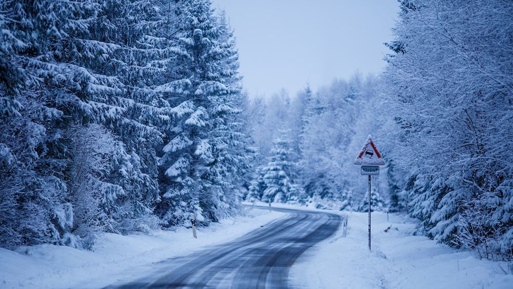 beautiful-scenery-iced-road-surrounded-by-fir-trees-covered-with-snow.jpg